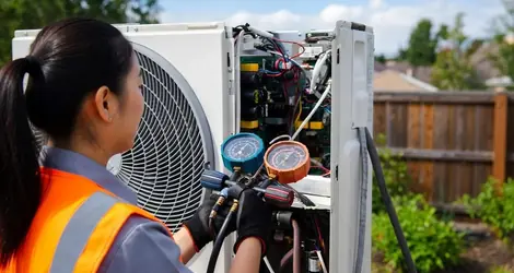 Female HVAC technician servicing an outdoor air conditioning unit in Magnolia TX